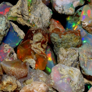 May include: A collection of rough opal stones in various shades of brown, gray, and white with iridescent flashes of color. The stones are irregular in shape and have a natural, unpolished appearance.