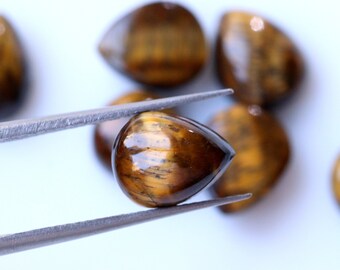May include: A collection of six teardrop-shaped tiger's eye gemstones. The stones are a mix of brown and gold with a shimmering effect.