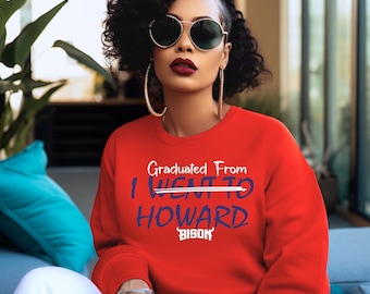 Könnte beinhalten: Ein roter Pullover mit dem Text "Graduated From I Went To Howard Bison" in lila Schrift.