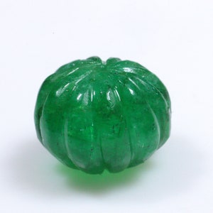 May include: A green carved gemstone bead with a rounded, fluted design.