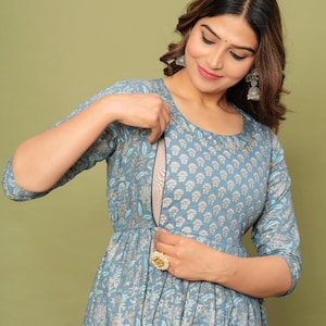 May include: A blue and silver patterned dress with a hidden nursing zipper. The dress has a round neckline and three-quarter sleeves.