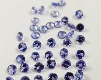 Pode incluir: Uma coleção de pedras preciosas redondas e facetadas de cor púrpura. As pedras preciosas estão espalhadas sobre uma superfície branca. O texto "Precious club" é visível na imagem.
