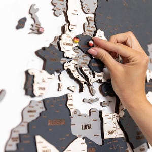 ピンフラッグ付きグレーの木製世界地図壁飾り