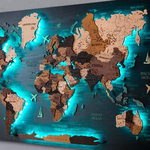 May include: A wooden world map with a dark blue background and illuminated blue LED lights. The continents are made of various shades of brown wood. Decorative elements include airplanes, sailboats, and a compass.