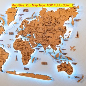 A wooden world map with illuminated regions and countries, mounted on a wall.
