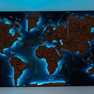 A large, illuminated world map with various countries and regions highlighted in blue light.