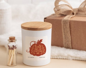 May include: A white candle with a bamboo lid and a brown pumpkin graphic with the text "Pumpkin Spice and Everything Nice". The candle is packaged in a brown box with a burlap ribbon and bow. A small glass jar with matches is also included.
