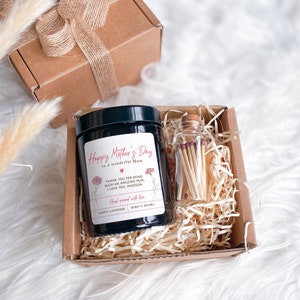 May include: A gift box set for Mother's Day with a black candle and a glass jar of matches. The candle has a label that reads "Happy Mother's Day to a wonderful Mum" and "Thank you for being such an amazing Mum. I love you. Madison." The candle is labeled "Hand poured with love, Scent: Lavender, Burn 25 Hours."