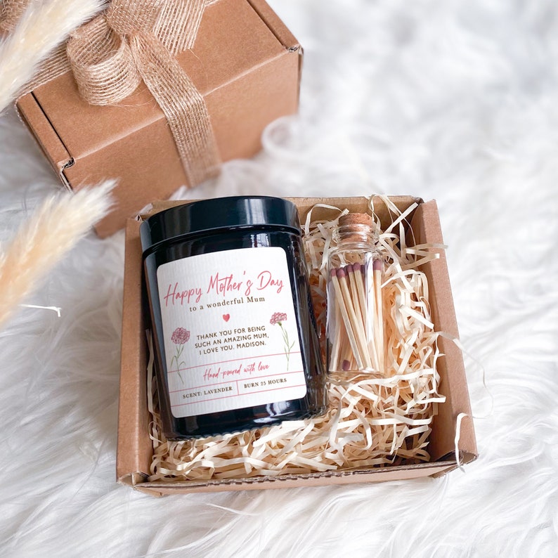 May include: A gift box set for Mother's Day with a black candle and a glass jar of matches. The candle has a label that reads "Happy Mother's Day to a wonderful Mum" and "Thank you for being such an amazing Mum. I love you. Madison." The candle is labeled "Hand poured with love, Scent: Lavender, Burn 25 Hours."