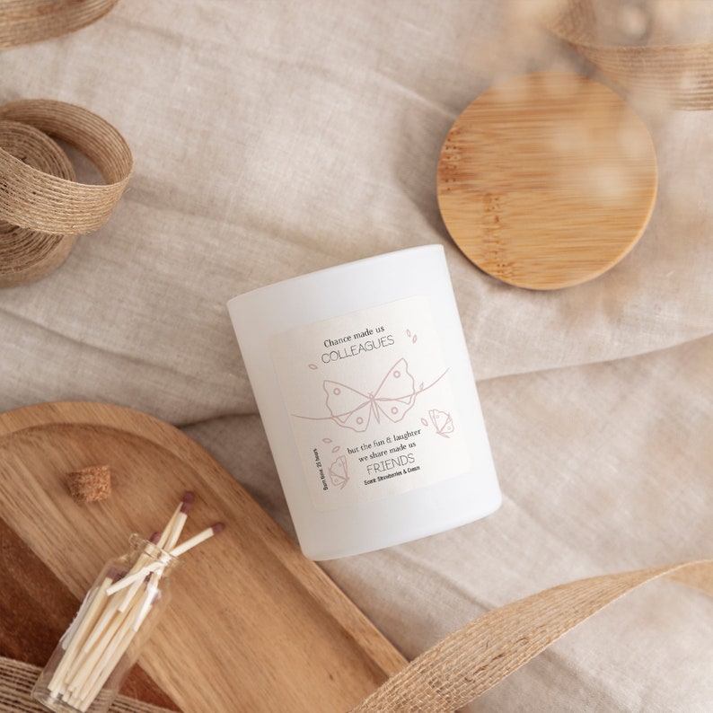 May include: White candle with a pink butterfly design and the text "Chance made us colleagues but the fun & laughter we share made us FRIENDS.  Scent: Sweet Strawberry & Cream."