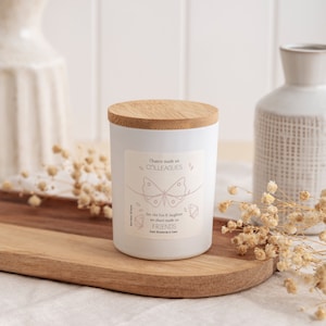 May include: White candle with a bamboo lid and a label that reads "Chance made us colleagues but the fun & laughter we share made us friends". The label features a pink butterfly graphic.