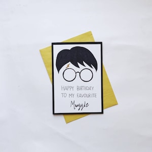 Op de afbeelding: Een zwart-witte verjaardagskaart met een cartoonillustratie van Harry Potter. De kaart luidt "Happy Birthday to my favourite Muggle".