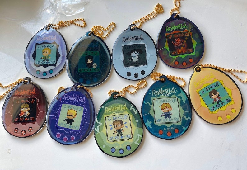May include: Nine colorful Resident Evil themed keychain charms shaped like a Tamagotchi. Each charm features a different character from the game series, including Leon, Chris, and Jill.
