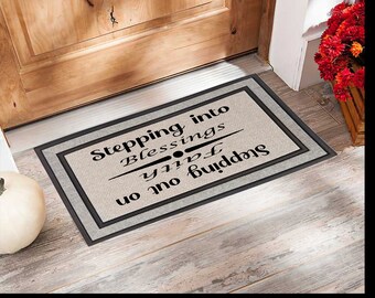 May include: A beige doormat with black text that reads "Stepping into Blessings, you're not just stepping in".