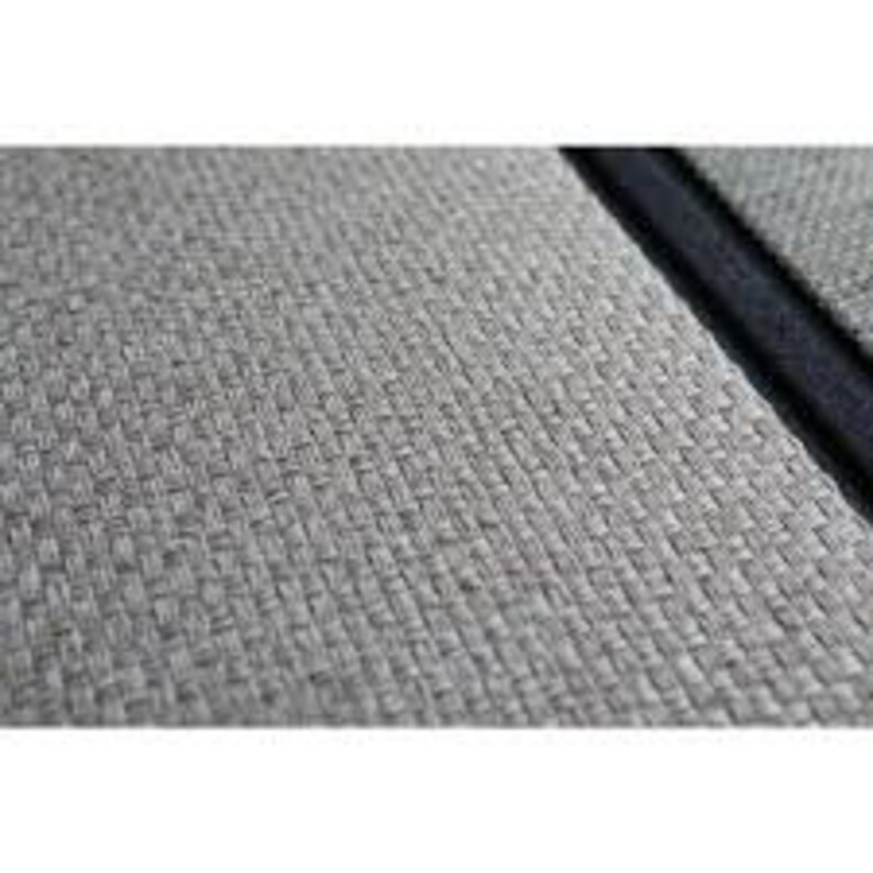 May include: Close-up of a gray woven fabric with a black border. The fabric has a subtle texture and a slightly raised pattern.