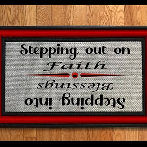 May include: A black and red doormat with the text "Stepping out on Faith, Stepping into Blessings".