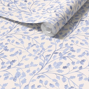 May include: A roll of wallpaper with a repeating pattern of blue watercolour oak leaves and branches on a cream background. The design has a soft, artistic feel, suitable for interior decor.
