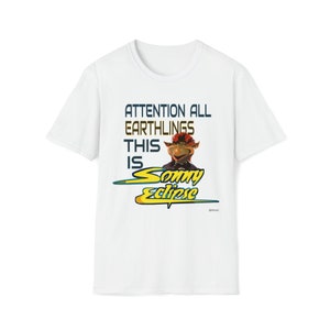 May include: White t-shirt with a graphic of a red-haired puppet with the text "Attention all Earthlings This is Sonny Eclipse".