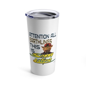 May include: White stainless steel tumbler with a blue lid. The tumbler features a graphic of a character with red hair and a yellow and blue logo that says "Attention all Earthlings This is Sonny Eclipse".