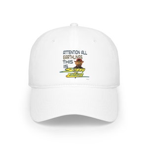 May include: White baseball cap with a curved brim. The cap features the text "ATTENTION ALL EARTHLINGS THIS IS Sonny Eclipse" in blue and yellow, along with a cartoon image of Sonny Eclipse.
