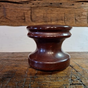 May include: A white ceramic mug with a black handle and the text "But First, Coffee" in a bold, black font. The mug is set against a blurred background, suggesting a cozy setting.