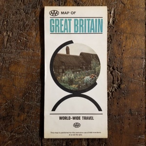 May include: A vintage AAA map of Great Britain with a photo of a thatched cottage in a garden. The map is for the exclusive use of AAA members and is not for sale.