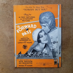 Puede incluir: Una portada de partitura vintage para la canción "Nobody But You" de la película "The Forward Pass" protagonizada por Douglas Fairbanks Jr. y Loretta Young. La portada presenta una fotografía en blanco y negro de los actores en un abrazo romántico en un campo de fútbol.
