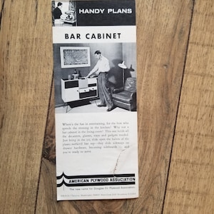 Pode incluir: Uma imagem em preto e branco de um armário de bar com portas deslizantes. O armário é feito de madeira e tem um design moderno. A imagem é de um folheto vintage intitulado "Planos práticos: Bar" e inclui o texto "American Plywood Association".