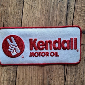 May include: Red and white embroidered patch with the text "Kendall Motor Oil" and a red circle with a white peace sign.