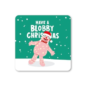 May include: A pink and white polka dot character wearing a red Santa hat and a red bow tie. The character is standing on a white surface with a green background. The text "Have a Blobby Christmas" is written in white letters on the green background.