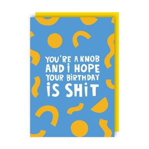 May include: A blue birthday card with yellow accents and the text "YOU'RE A KNOB AND I HOPE YOUR BIRTHDAY IS SHIT" in white. The card has a yellow border and a pattern of yellow shapes.