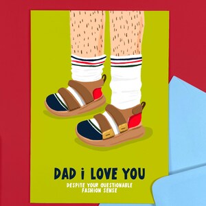 May include: A humorous greeting card featuring an illustration of legs in sandals and striped socks. The text reads "DAD I LOVE YOU DESPITE YOUR QUESTIONABLE FASHION SENSE" on a green background, with a red border.