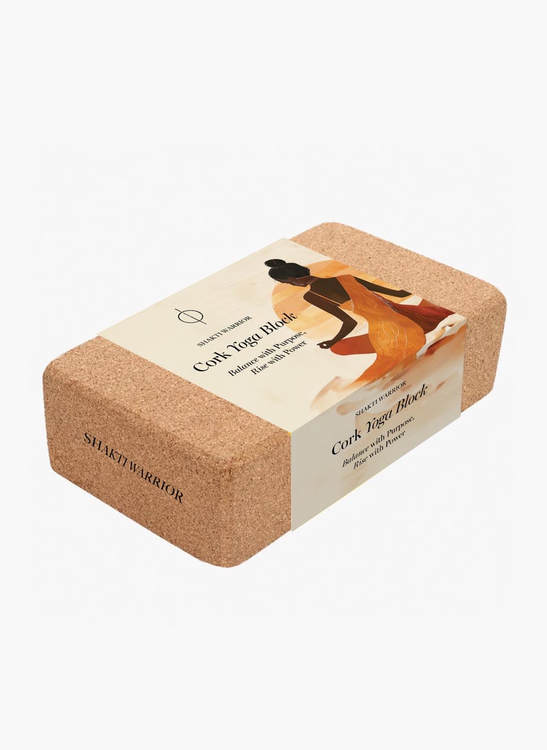 K&ouml;nnte beinhalten: Ein Kork-Yogablock mit dem Text "SHAKTI WARRIOR" und "Cork Yoga Block: Balance with Purpose, Rise with Power" auf der Seite. Der Block ist braun und hat eine nat&uuml;rliche Korkstruktur.