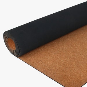 May include: A rolled-up black yoga mat with a cork bottom. The mat is partially unrolled, revealing the cork surface.