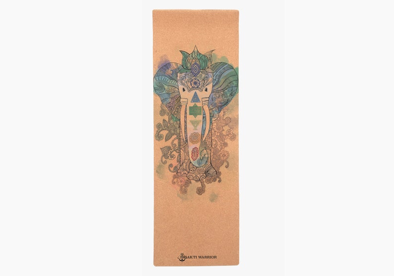 Puede incluir: Una esterilla de yoga de corcho marr&oacute;n con un dise&ntilde;o de mandala colorido que presenta una cabeza de elefante y el texto "Sakti Warrior".