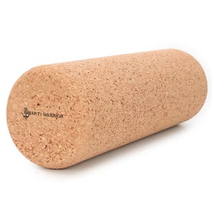 May include: A cylindrical cork foam roller with rounded ends. The roller is light brown with a textured surface. The words "Shakti Warrior" are printed on one end. This fitness tool is used for muscle recovery and massage.