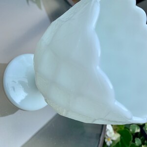 K&ouml;nnte beinhalten: Eine wei&szlig;e Milchglas-Bonbonschale mit gewelltem Rand und einem Sockel.