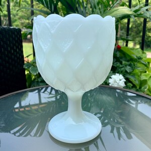 K&ouml;nnte beinhalten: Wei&szlig;e Milchglas-Fu&szlig;schale mit Diamantmuster. Die Schale hat einen gewellten Rand und einen breiten Standfu&szlig;.
