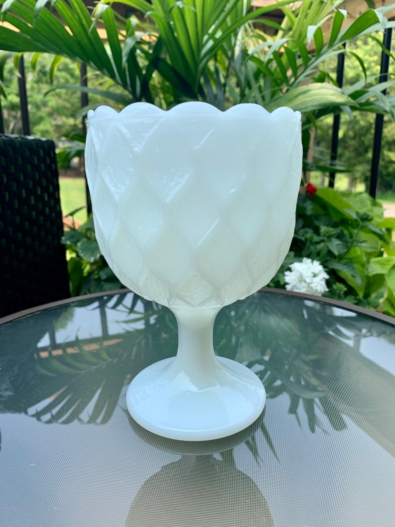 K&ouml;nnte beinhalten: Wei&szlig;e Milchglas-Fu&szlig;schale mit Diamantmuster. Die Schale hat einen gewellten Rand und einen breiten Standfu&szlig;.