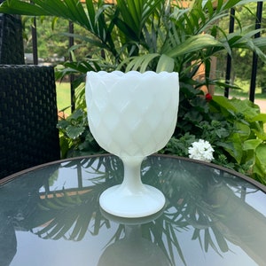 K&ouml;nnte beinhalten: Wei&szlig;e Milchglasvase mit Diamantmuster. Die Vase hat einen breiten, runden Boden und einen hohen, schlanken Stiel.