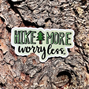 May include: A green and white sticker with the text "HIKE MORE worry less" and a small green tree illustration.