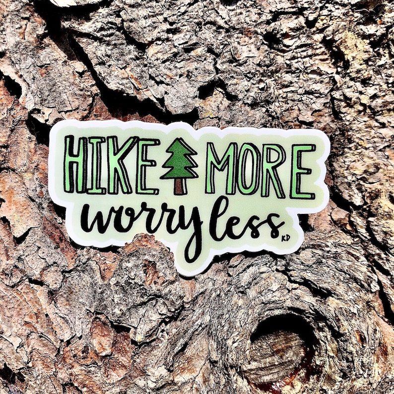 May include: A green and white sticker with the text "HIKE MORE worry less" and a small green tree illustration.