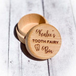 May include: A small wooden box with a lid, engraved with the text "Kenlee's Tooth Fairy Box" and a small tooth icon.