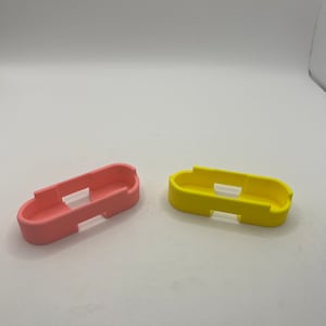May include: Two silicone phone cases, one pink and one yellow. The cases are designed to fit a phone with a flat edge on the top and bottom.