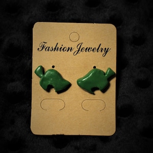 May include: A pair of green leaf-shaped earrings on a brown card with the text "Fashion Jewelry".