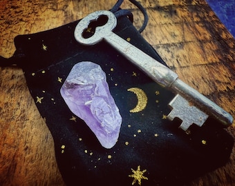 Llave antigua con punta de cristal de amatista, amuleto de oportunidad y protección, en bolsa de terciopelo negro con estrellas y luna creciente, talismán.