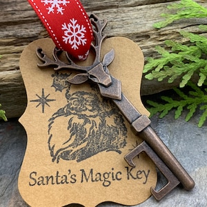 May include: A brown paper ornament shaped like a key with a reindeer head on the top. The key has a bottle opener on the bottom. The ornament has the text "Santa's Magic Key" printed on it.