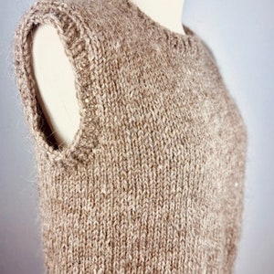 Puede incluir: Un chaleco de punto marrón sin mangas con un patrón de punto texturizado.
