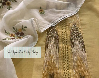 May include: A yellow cotton fabric with a white sheer overlay. The fabric has a beaded trim with a lace design. The overlay has embroidered flowers. The text "A Style For Every Story" is printed on the fabric.