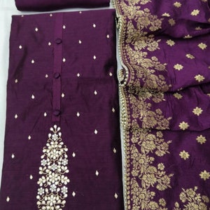May include: A purple embroidered dress fabric with a floral design and pearl trim. The fabric is a blend of silk and cotton.